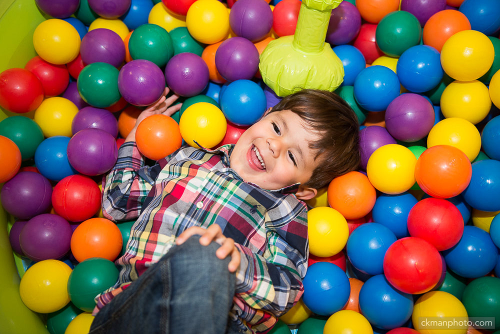 Boy smiling happily in the ball pit